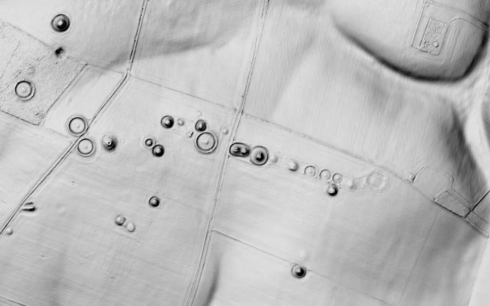 LiDAR terrain shading of Normanton Down in Wiltshire: a line of round mounds and rings across a field.